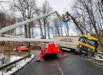 Kamion visel nad srázem jen na svodidlech. Vytáhli jej hasiči